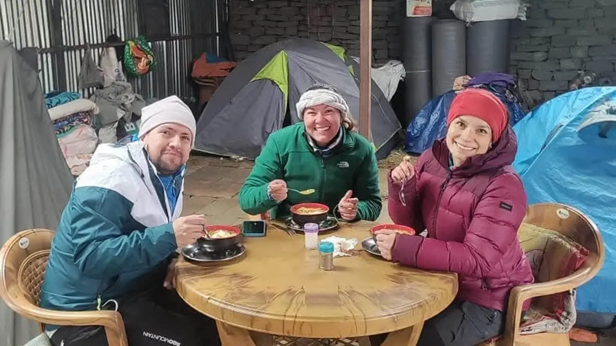 Trekkers, wearing warm cloth, enjoying hot snacks